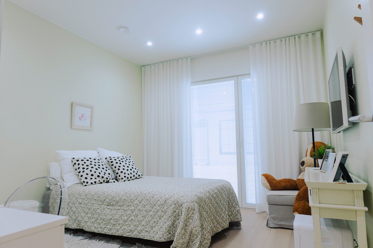 Valoisa ja moderni makuuhuone, jossa huolellisesti pedattu sänky, valkoiset verhot ja pehmeä LED-valaistus. Tutustu LedStore.fi:n uusimpiin referenssikohteisiin vuodelle 2025 ja inspiroidu seuraavaa sisustusprojektia varten!