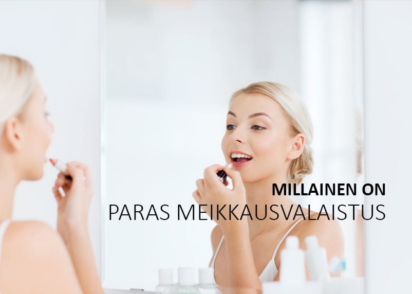 Blondi nainen levittää huulipunaa LED-valojen valaisemaan peiliin. Kosmeettiset tuotteet ovat pöydällä. Kuvan päällä on suomenkielinen teksti: "MILLAINEN ON PARAS MEIKKAUSVALAISTUS".